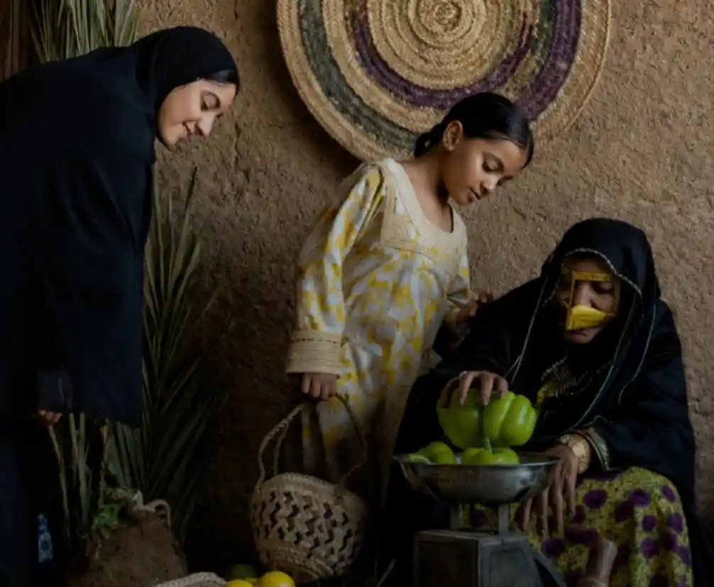 Women and child handling fresh vegetables in a traditional setting, representing local food access and community-based retail