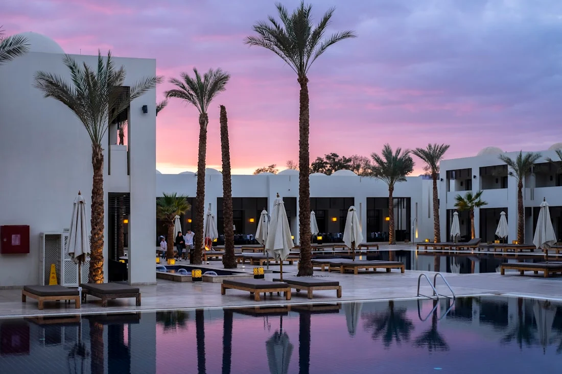 Resort pool with palm trees at dusk