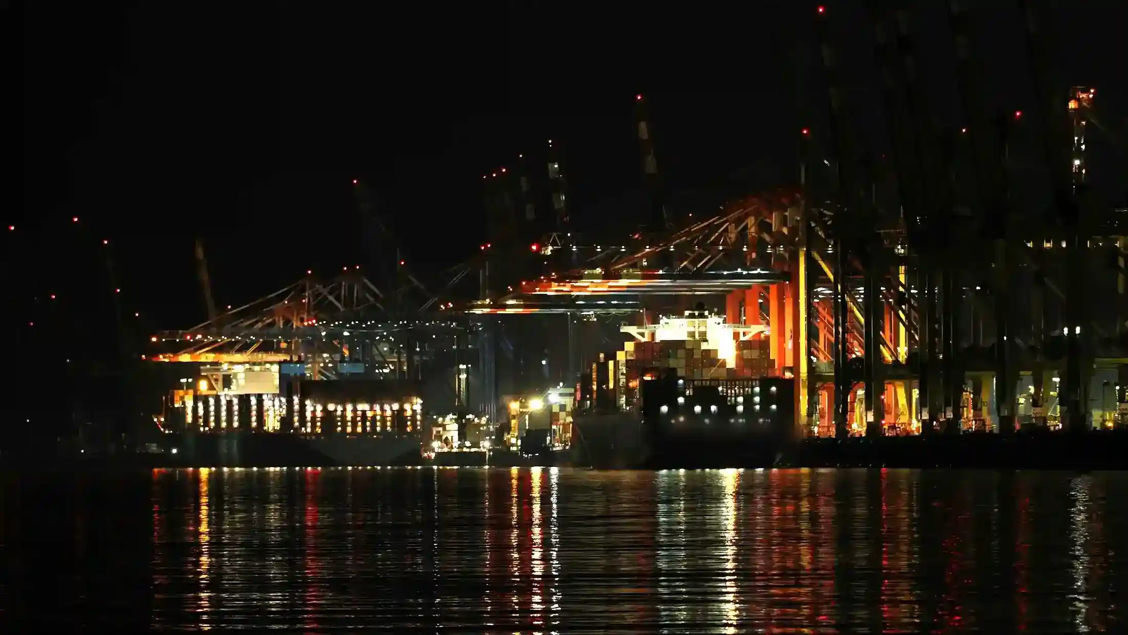 Ship-to-shore cranes working a container vessel at night